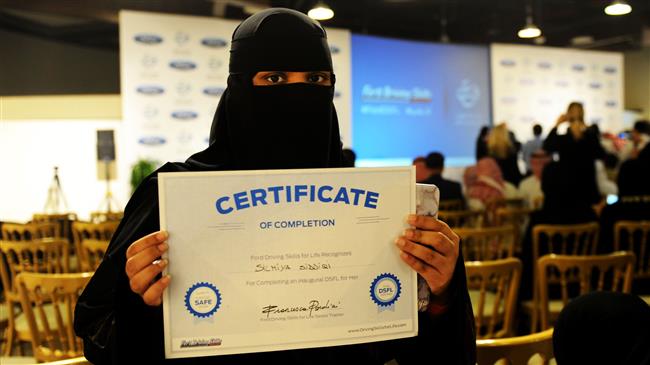 In this file photo taken on March 7, 2018, a Saudi woman poses for a photo with a certificate after completing a driving course in Jeddah. (Photo by AFP)