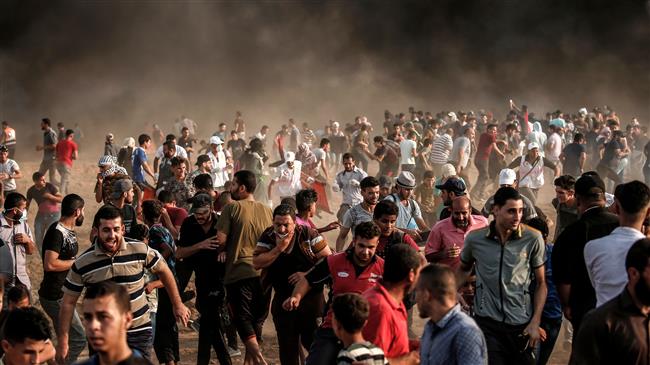 Palestinian protesters demonstrate near the fence east of Gaza City on August 31, 2018, as smoke rises from burning tires and Israeli tear gas canisters. (Photo by AFP)
