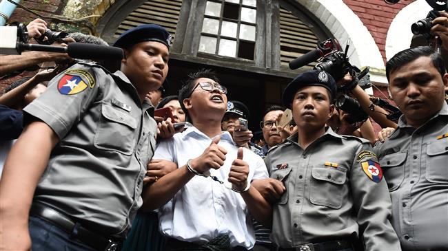 Myanmar journalist Wa Lone (C) is escorted by police after being sentenced by a court to jail in Yangon on September 3, 2018. (Photo by AFP)