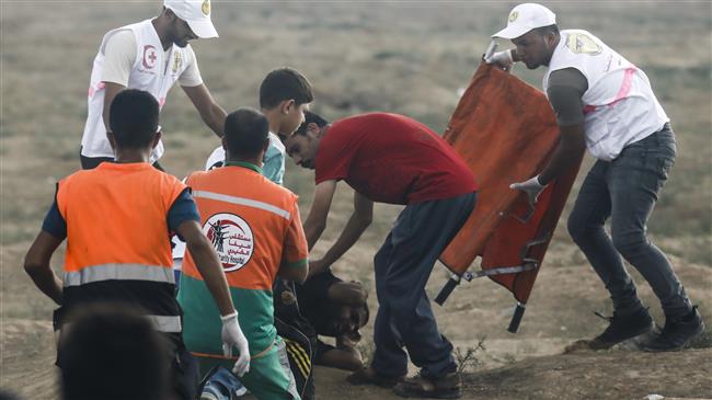 Palestinian paramedics tend to a fallen injured protester during clashes following a demonstration at the border between the besieged Gaza Strip and occupied territories on September 7, 2018. (Photo by AFP)