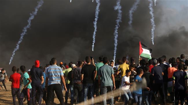 Palestinian protesters watch as teargas grenades fired by Israeli forces fall during clashes following a demonstration along the border between the Gaza Strip and the Israeli-occupied territories east of Gaza City on September 7, 2018. (Photo by AFP)