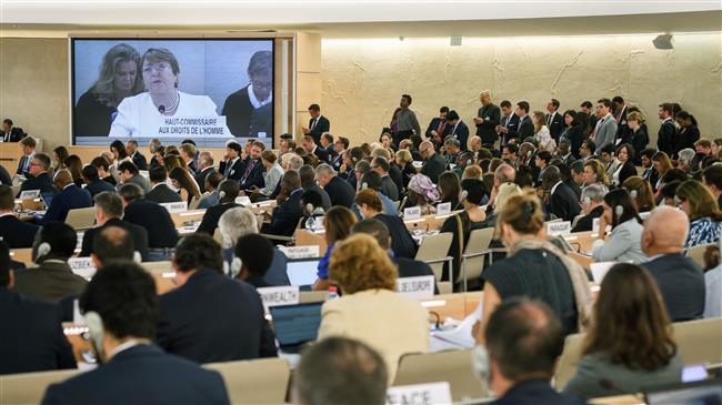 The United Nations (UN)’s High Commissioner for Human Rights Michelle Bachelet is seen on a TV screen delivering her first speech on the opening day of the 39th UN Council of Human Rights in Geneva, on September 10, 2018. (Photo by AFP)