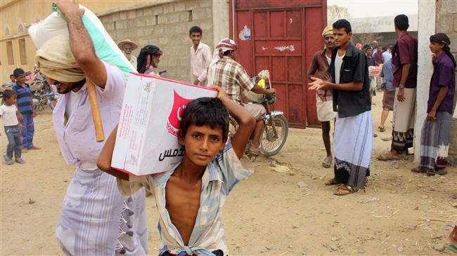 This picture taken on July 17, 2018 shows displaced Yemenis from Hudaydah receiving food aid from a Japanese NGO in the northern district of Abs, Hajjah province, Yemen. (Photo by AFP)