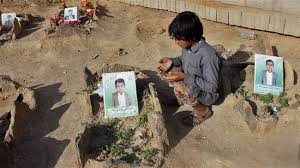 A Yemeni child recites prayers by the graves of schoolboys, who were killed while on a bus that was hit by a Saudi-led coalition airstrike in the northwestern Yemeni province of Sa’ada in August, at a cemetery in the province on September 4, 2018. (Photo by AFP)
