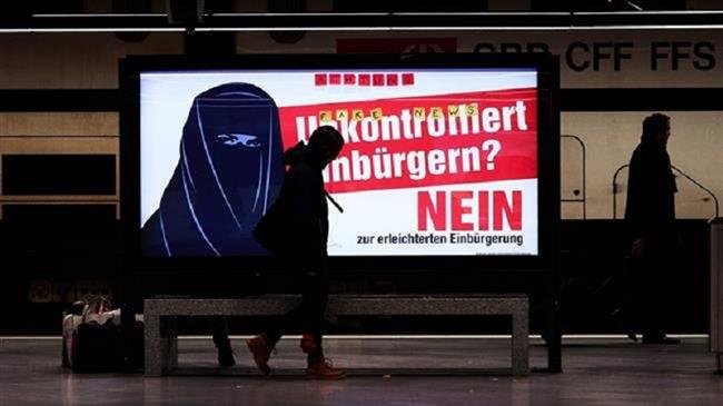 The file photo shows an electoral poster of the Swiss far-right party reading “Uncontrolled Naturalization? No” in German with the illustration of a woman wearing a burka at a train station in Zurich, Switzerland, February 7, 2017. (Photo by AFP)