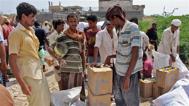 Yemenis receive humanitarian aid donated by the World Food Programme (WFP) in the northern province of Hajjah on September 25, 2018. (Photo by AFP)