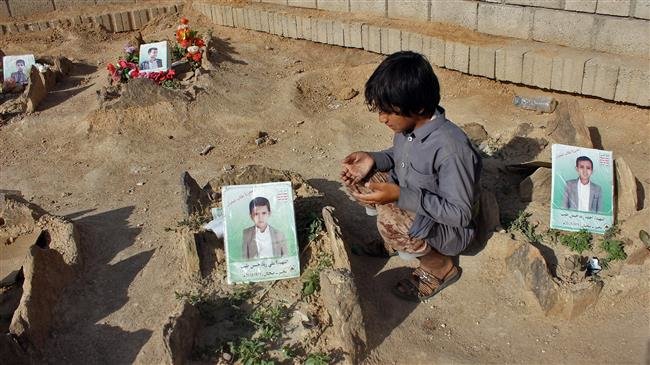 A Yemeni child recites a prayer by the graves of schoolboys who were killed while on a bus that was hit by a Saudi-led coalition air strike on the Dahyan in the province of Sa’ada, September 4, 2018. (Photo by AFP)