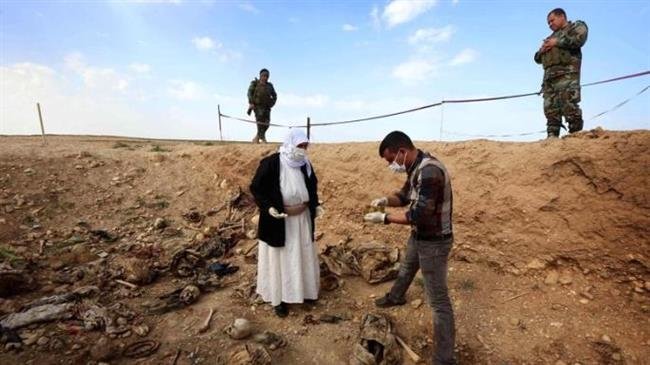 In this file picture, members of the Izadi minority group search in the remains of people killed by Daesh a day after Kurdish forces discovered a mass grave near the Iraqi village of Sinuni in the northwestern Sinjar area. (Photo by AFP)