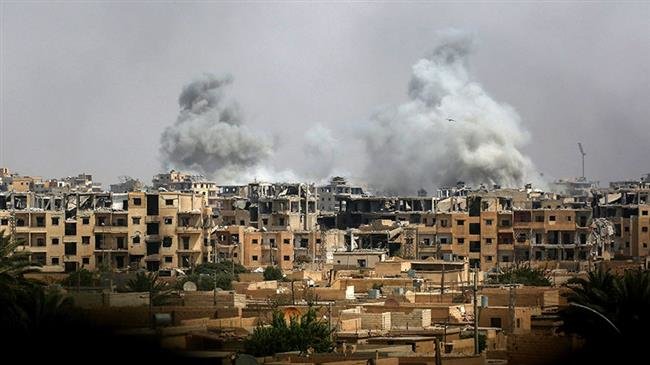 A picture taken on September 5, 2017 shows smoke billowing out following a coalition air strike in the western al-Daraiya neighborhood of the embattled northern Syrian city of Raqqah. (Photo by AFP)