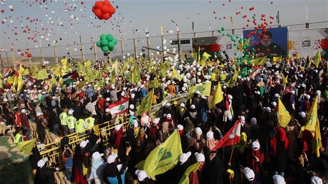 Lebanese people carry flags of the Hezbollah resistance movement and national flags during a demonstration to commemorate the Quds Day in the village of Maroun al-Ras on June 8, 2018. (Photo by AFP)