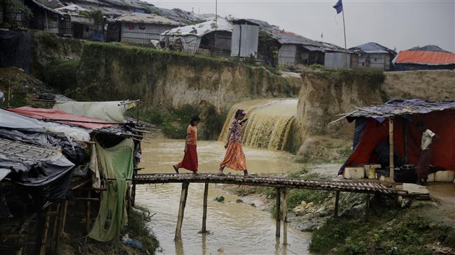 Rohingya Muslim refugee girls are seen crossing a makeshift bamboo bridge at Kutupalong refugee camp in Bangladesh, on August 28, 2018. (Photo by AP)