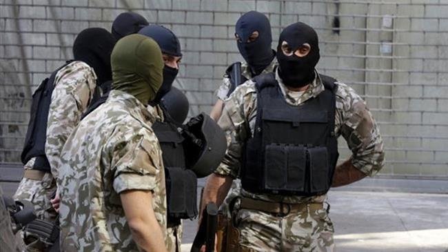 Lebanese security forces stand guard as others carry out documents and computers from a shop that handles money transfers on Hamra street, in Beirut, Lebanon, on March 8, 2017. (Photo by the Associated Press)