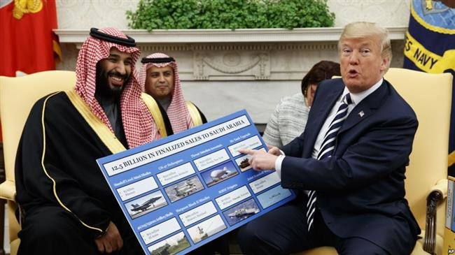 US President Donald Trump shows a chart highlighting arms sales to Saudi Arabia during a meeting with Saudi Crown Prince Mohammed bin Salman in the Oval Office of the White House, March 20, 2018. (Photo by AFP)