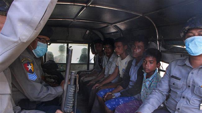 Police escort a group of Rohingya men and a boy in Kyauktan township south of Yangon on November 16, 2018 after their boat washed ashore. (Photo by AFP)