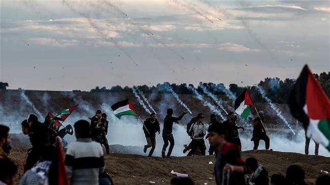 Palestinians react to tear gas fired by Israeli forces during a protest on November 23, 2018, in the eastern outskirts of Gaza City, near the border with the occupied territories. (Photo by AFP)