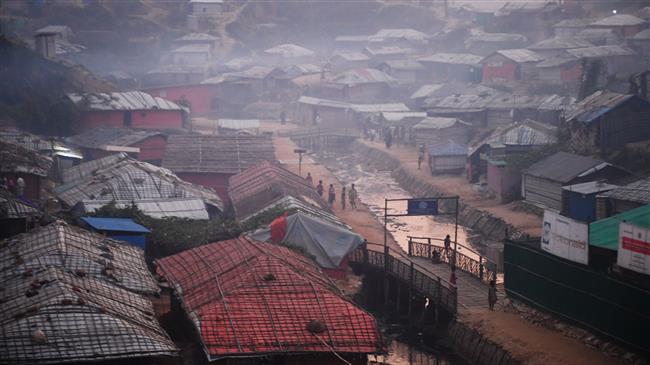 Rohingya refugees walk back to their tent at the Kutupalong refugee camp in Bangladesh, during dusk on November 18, 2018. (Photo by AFP)