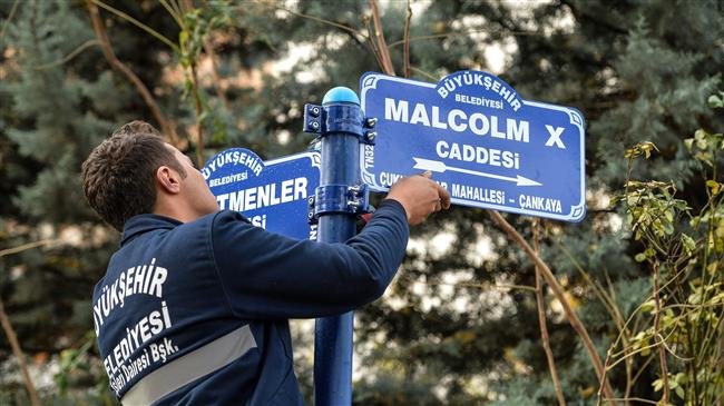 A metropolitan municipality worker hangs the road sign for