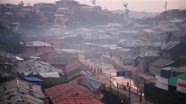 Rohingya refugees walk back to their tent during dusk at the Kutupalong refugee camp in Bangladesh on November 18, 2018. (Photo by AFP)