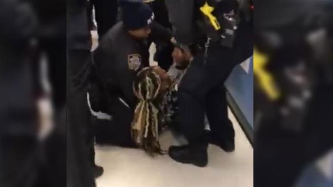 Screenshot of a Facebook video posted by Nyashia Ferguson showing a police officer violently ripping a baby from his mother at an incident at a Brooklyn food stamp office in New York City, United States.
