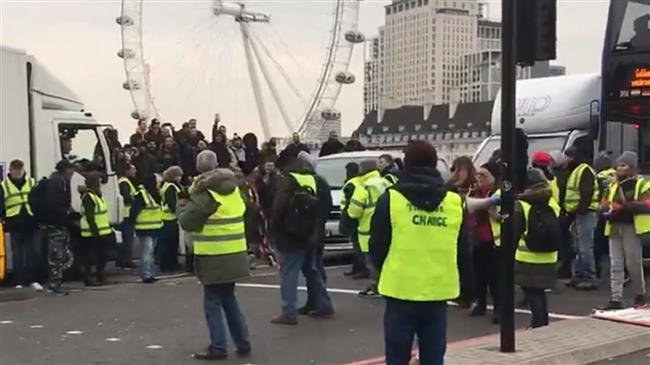 Pro-Brexit protesters are seen blocking London’s Westminster Bridge, adopting the iconic "Yellow Vests" used by anti-government protesters in France, on December 14, 2018. (Image via Twitter)