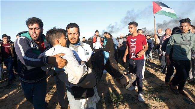 A Palestinian carries a young man away from the scene of demonstrations on the border between Israel and Khan Yunis in the southern Gaza Strip, on December 14, 2018. (Photo by AFP)