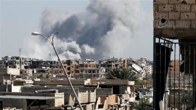 In this file picture, smoke rises near a stadium after an airstrike by the US-led coalition forces, in Raqqah, Syria. (Photo by Reuters)