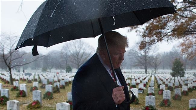 US President Donald Trump walks past tombstones on December 15, 2018 during an unscheduled visit to Arlington National Cemetery. (Photo by AFP)