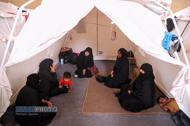 طلاب خواهر در اردوگاه اسکان سیل زدگان به صحبت با خانم های سیل زده مشغولند