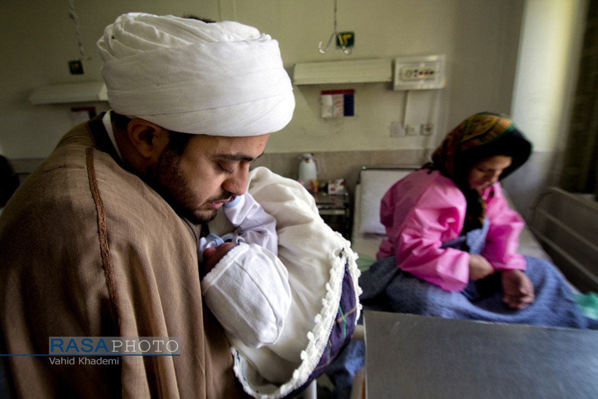 عکسی زیبا از لحظه خواندن اذان در گوش یک نوزاد که در روز عید سعید غدیر متولد شده است