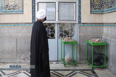 طلبه ای برنامه ساغات دروس علماء و مراجع تقلید که در مسجد اعظم برگزار میشود را میبیند