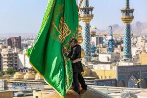 آیین تعویض پرچم گنبد منور رضوی در روز میلاد امام رئوف (ع)