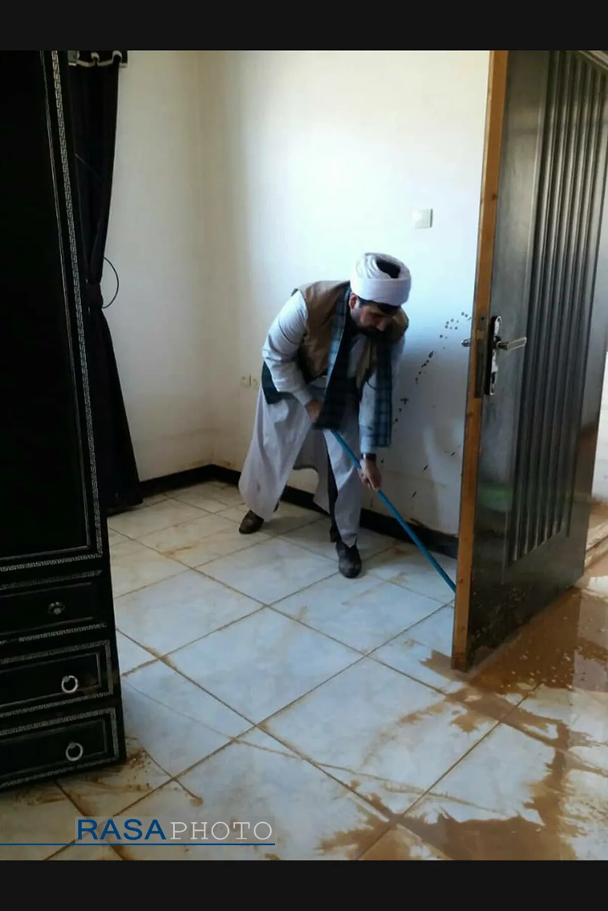 استاد حوزه علمیه به همراه طلاب در حال کمک رسانی به مردم سیل زده شهرستان دلفان